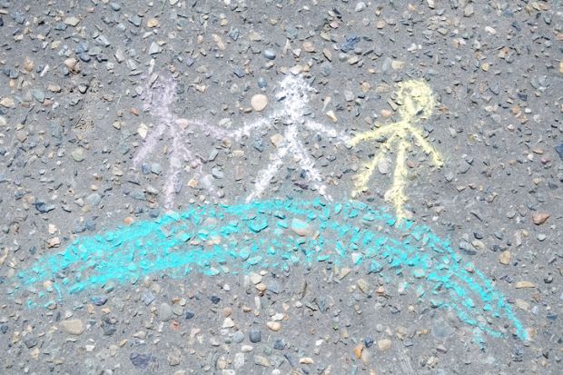 Chalk figures holding hands on a globe