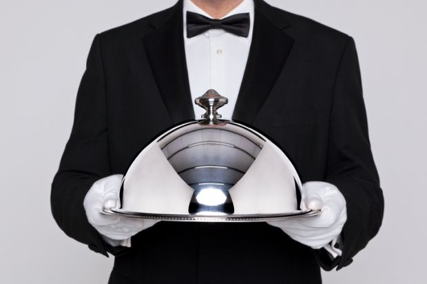 Waiter holding a silver cloche