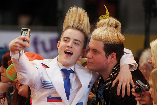 Jedward taking a selfie with a fan illustrating the academic star system
