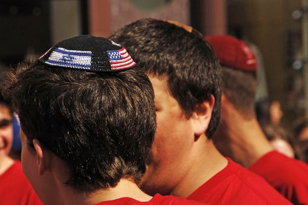 Young man wearing yarmulke with American and Israeli flags Young man wearing yarmulke with American and Israeli flags