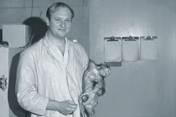 John Gluck holding monkey research subject, 1968
