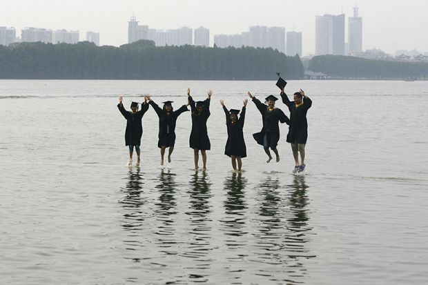 graduates jump in shallow water