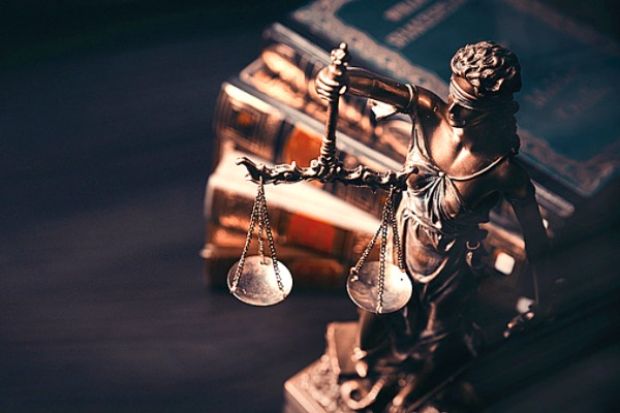 A justice statue next to some books