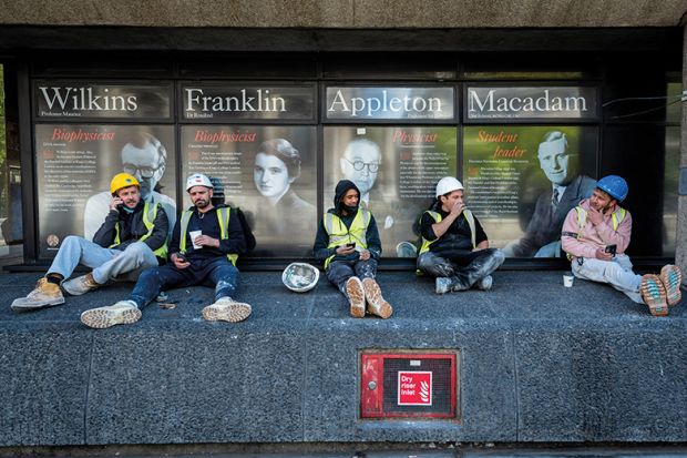 Workmen sit on a wall outside King’s College London Workmen sit on a wall outside King’s College London