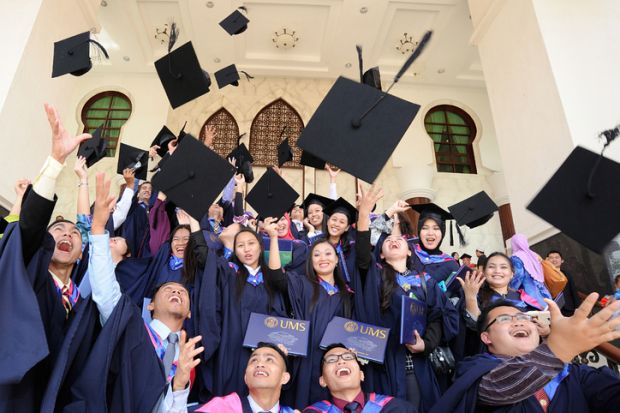 Kota Kinabalu, Sabah Malaysia. November 25, 2013  A group of graduates tossing their caps in celebration of their graduation at Universiti Malaysia Sabah.