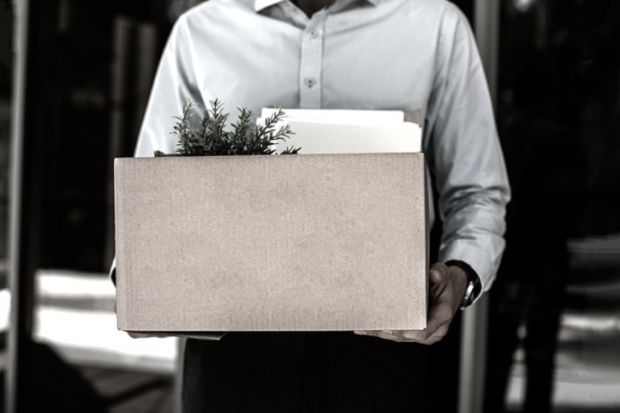 A man carries a box of his belongings, illustrating redundancy A man carries a box of his belongings, illustrating redundancy