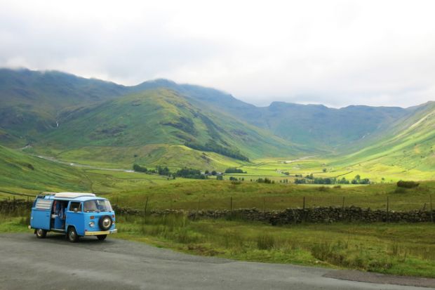 Lake District National Park, Windermere, England - July, 26th, 2017A blue classic VW Bus from 1973 driving westbound on Hawkshead passroad, one of the highest passroads in Great Britain