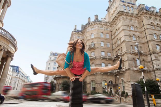 A woman leapfrogs a bollard in London