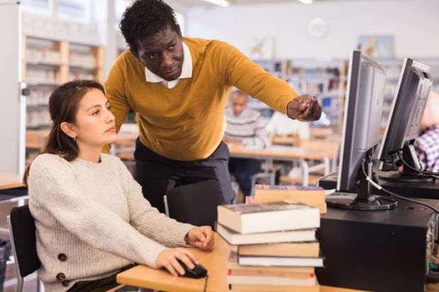A librarian helping a student