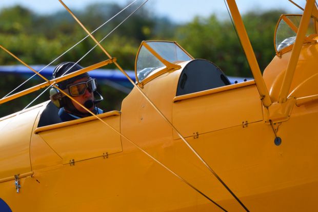 Little Gransden, Cambridge, England - August 28, 2022 Yellow Tiger Moth Biplane close Up of Pilot in Flying Goggles,