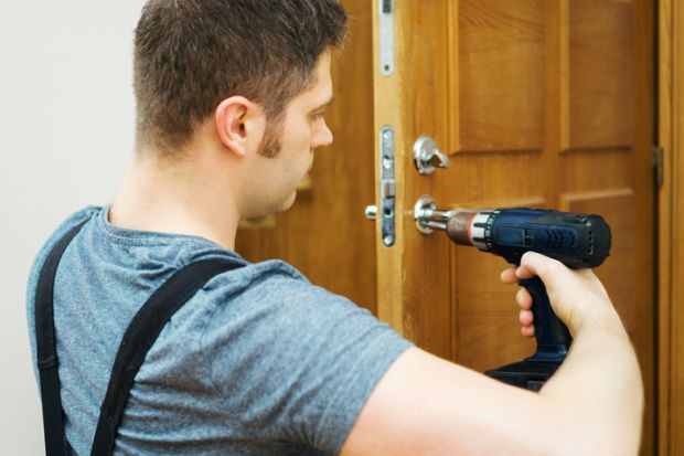 A locksmith fixes a door, symbolising T-level pathways to university admission