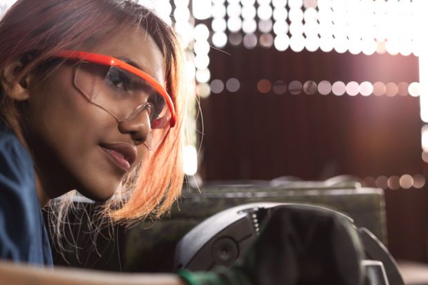 An Asian woman works heavy machinery An Asian woman works heavy machinery