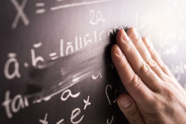 Making mistakes and wrong answer concept. Hand wiping math formula off blackboard in classroom at school. Student or teacher correcting incorrect calculation on chalkboard.
