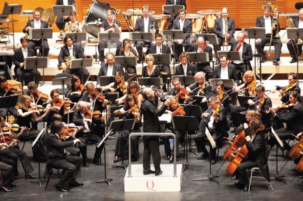 Male conductor conducting orchestral concert