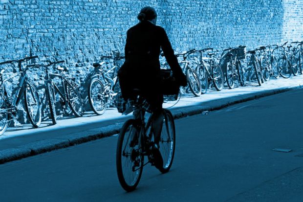Male cyclist riding bike, Trinity Lane, Cambridge