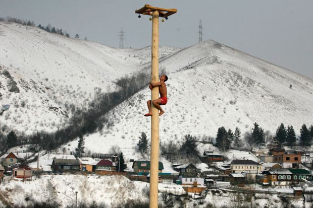 Man climbing wooden column, Krasnoyarsk, Siberia
