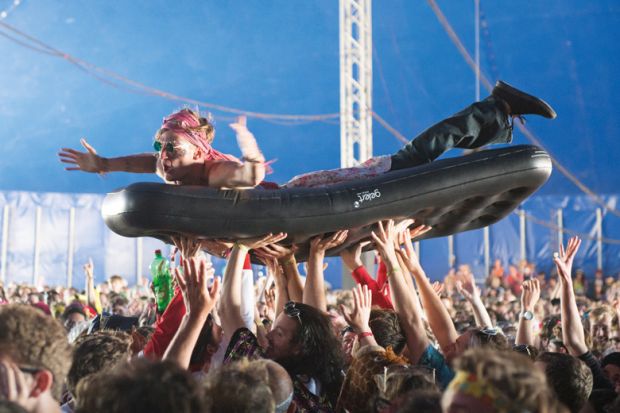 Man crowd surfing on inflatable bed, Bestival 2015, Isle of Wight