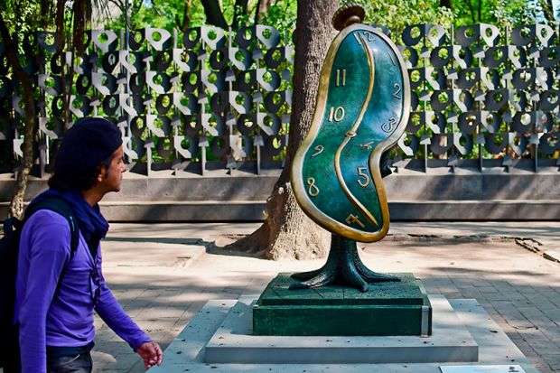 A man looks at the "Dance of Time I" sculpture by Spanish artist Salvador Dali. To illustrate that funding provided for PhD researchers is often not enough to cover the completion of a doctorate.