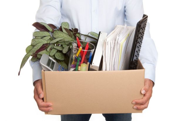 Man holding a box filled with work-related items Man holding a box filled with work-related items