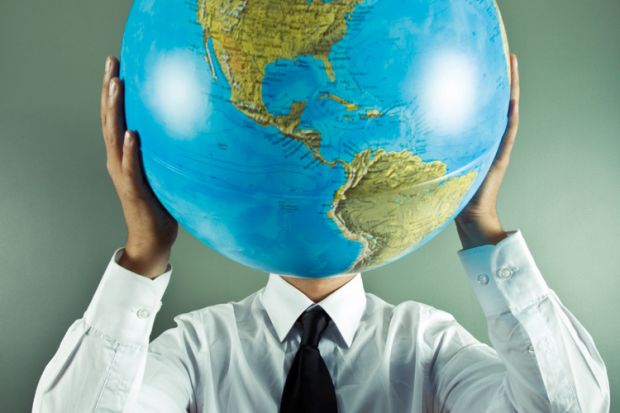 Man holding globe in front of face