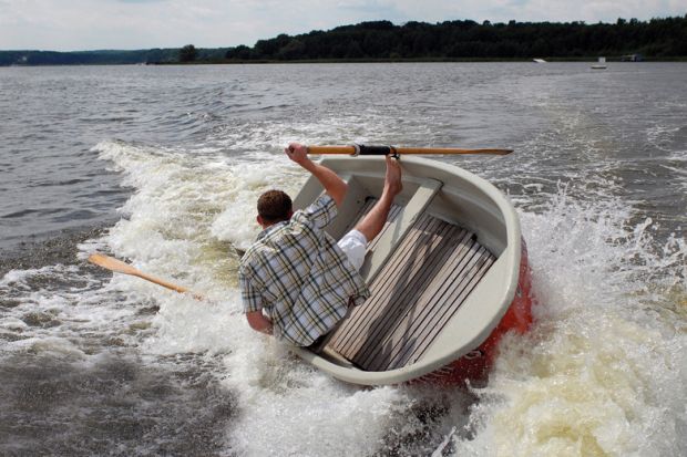 Man holding onto capsizing boat