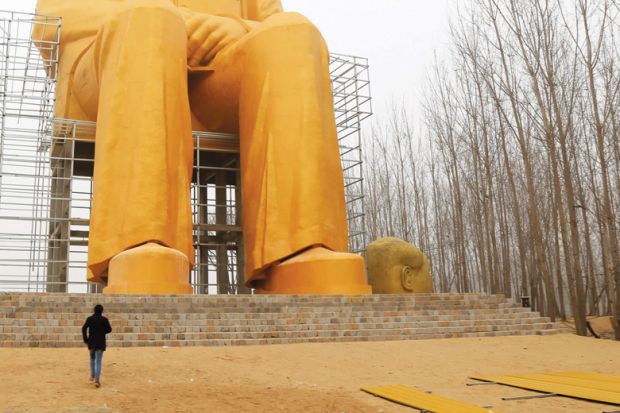 Man looking at statue of Mao Zedong, China, 2016