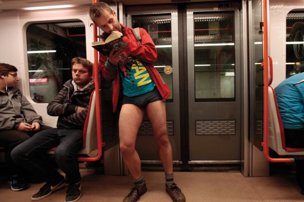 Man reading book on subway train, No Pants Subway Ride, Prague, 2015