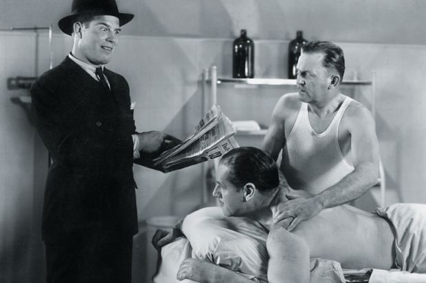 Man reading newspaper to two men Man reading newspaper to two men