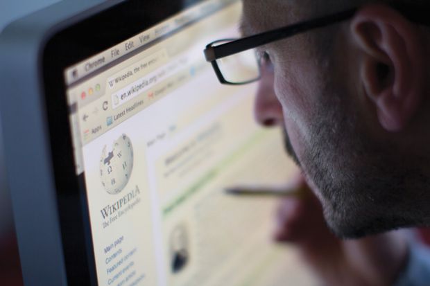Man reading Wikipedia page on desktop computer (PC)