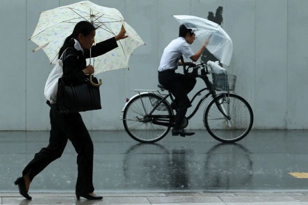 Man rides a bicycle ahead of woman walking
