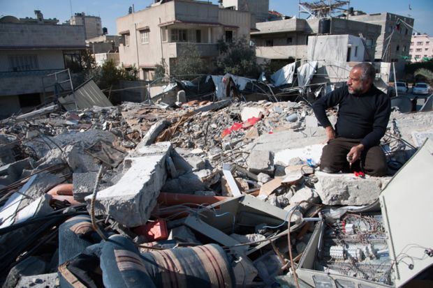 Man sits in rubble of Palestinian National Authority Council of Ministers building Man sits in rubble of Palestinian National Authority Council of Ministers building