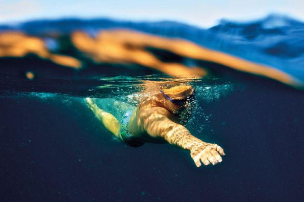 Man swimming underwater in ocean