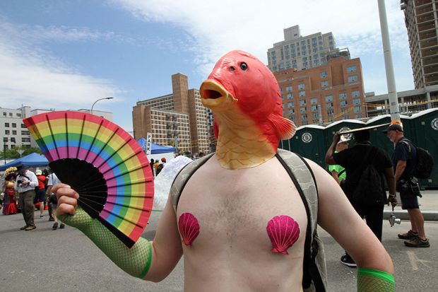 A man wearing a fish mask and holding a rainbow fan during the Mermaid Parade in Brooklyn. To illustrate that academia must ‘engage with’ anti-woke research critics such as Charlotte Gill, who criticised research on ‘queer fish’.