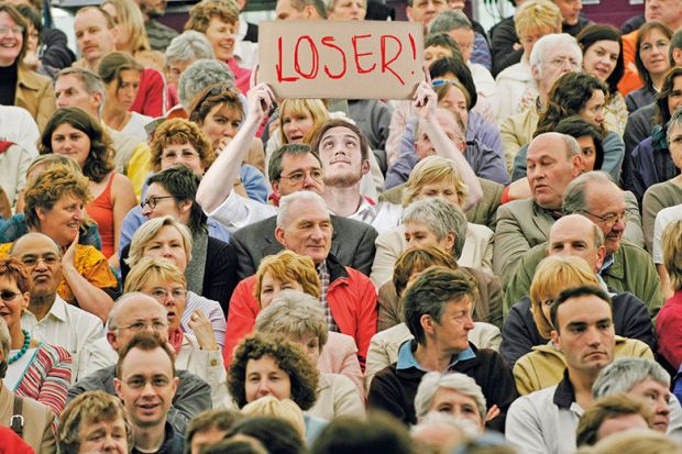 Man with loser sign in crowd