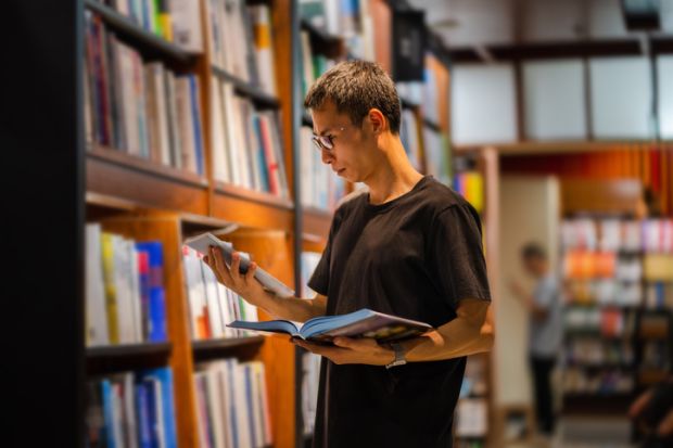  man chooses suitable books while reading in the library