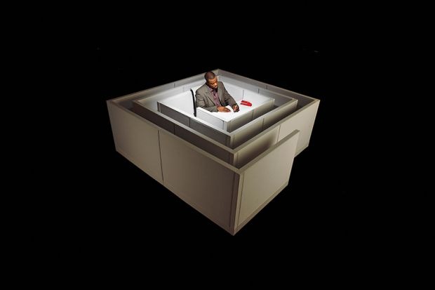 Floating in space, a black man sits at a desk in the middle of a maze