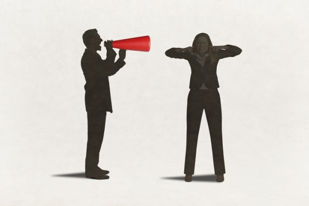 A man with a megaphone yells at a woman with her fingers in her ears A man with a megaphone yells at a woman with her fingers in her ears