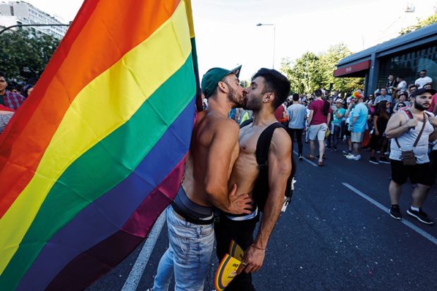 Men kissing with pride flag