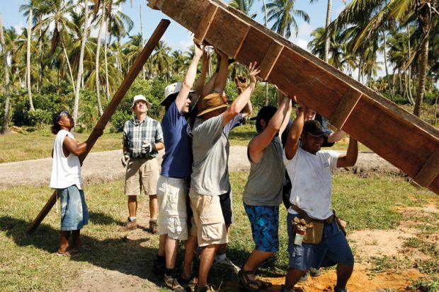 Men lifting wooden construction frame, Tasbapauni, Nicaragua