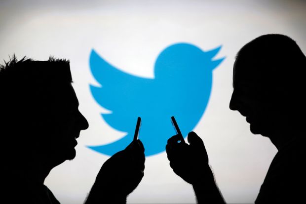 Men using smartphones against Twitter logo backdrop Men using smartphones against Twitter logo backdrop