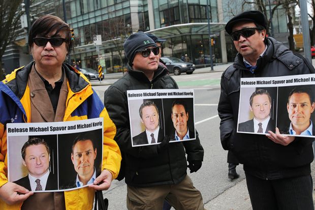 Protesters hold signs calling for the release of Canadian citizens Michael Spavor and Michael Kovrig outside British Columbia Superior Court in March 2019