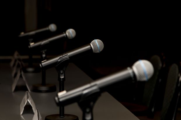 A row of microphones, symbolising debate