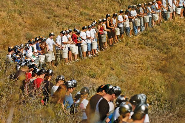 Miners standing in a line in a field