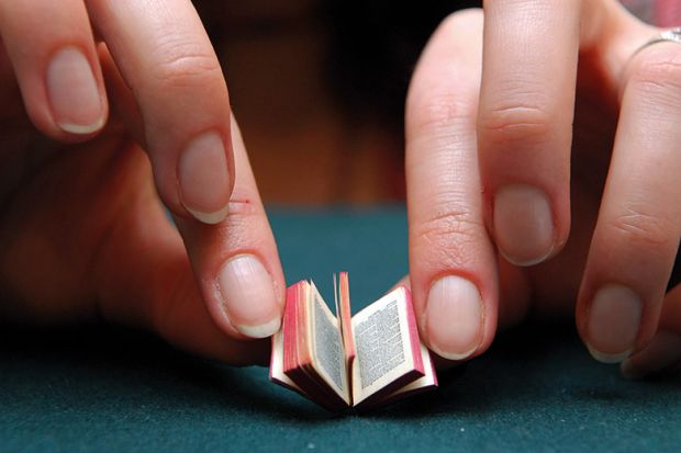 Person reading miniature book