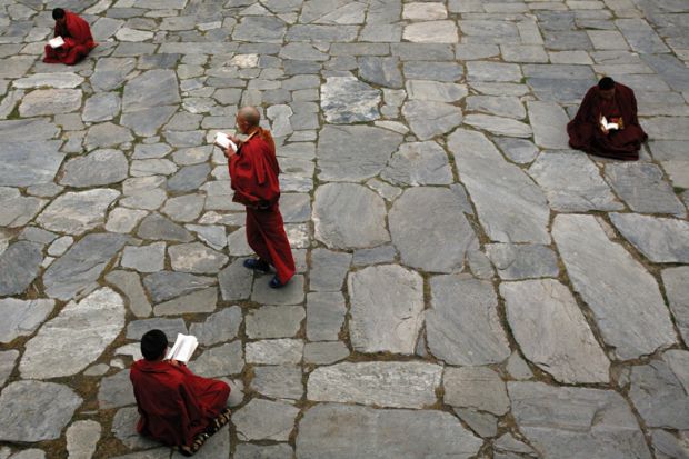 Monks studying books in the courtyard
