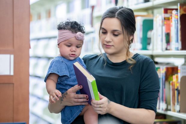 A mother with her daugher in a library, illustrating academic parenthood A mother with her daugher in a library, illustrating academic parenthood