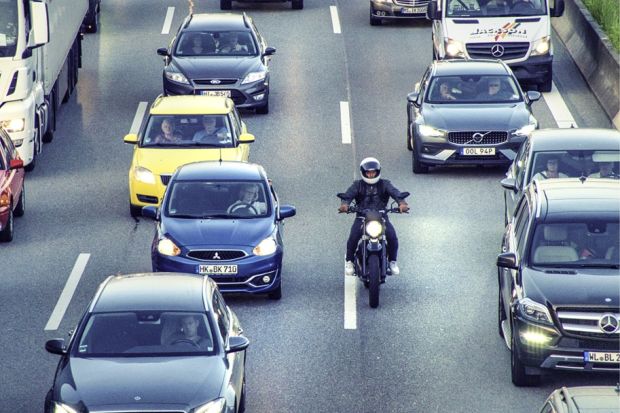 A motorbike slips through a traffic jam, symbolising rapid completion of a PhD A motorbike slips through a traffic jam, symbolising rapid completion of a PhD