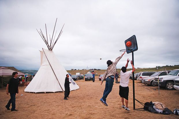 Native American protesters play basketball