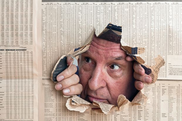 Man peeks through hole in newspaper