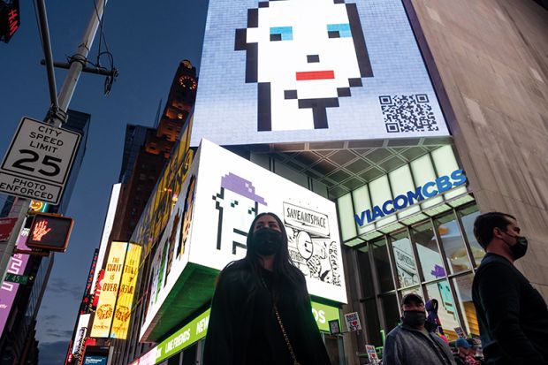 People walk past CryptoPunk non-fungible token (NFT) on a digital billboard in Times Square on May 12, 2021